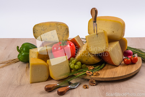 Image of Bosnian traditional cheese served on a wooden container with peppers, parade and onions isolated on a white background