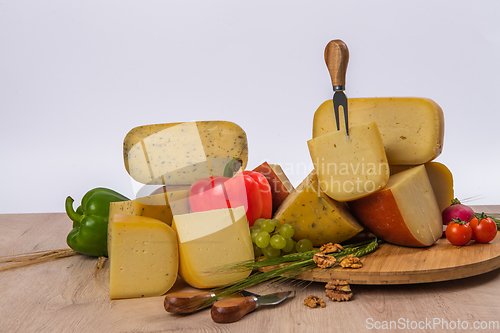 Image of Bosnian traditional cheese served on a wooden container with peppers, parade and onions isolated on a white background