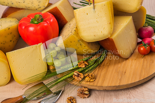 Image of Bosnian traditional cheese served on a wooden container with peppers, parade and onions isolated on a white background