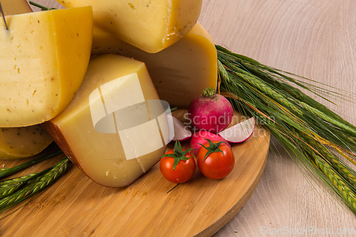 Image of Bosnian traditional cheese served on a wooden container with peppers, parade and onions isolated on a white background