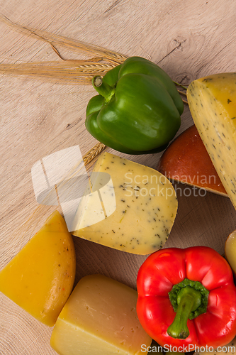 Image of Bosnian traditional cheese served on a wooden container with peppers, parade and onions isolated on a white background