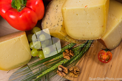 Image of Bosnian traditional cheese served on a wooden container with peppers, parade and onions isolated on a white background