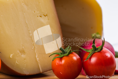 Image of Bosnian traditional cheese served on a wooden container with peppers, parade and onions isolated on a white background