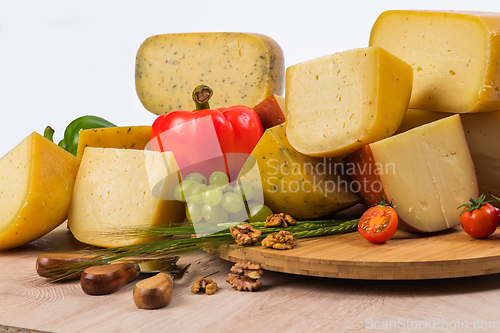 Image of Bosnian traditional cheese served on a wooden container with peppers, parade and onions isolated on a white background