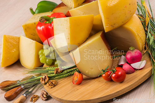 Image of Bosnian traditional cheese served on a wooden container with peppers, parade and onions isolated on a white background