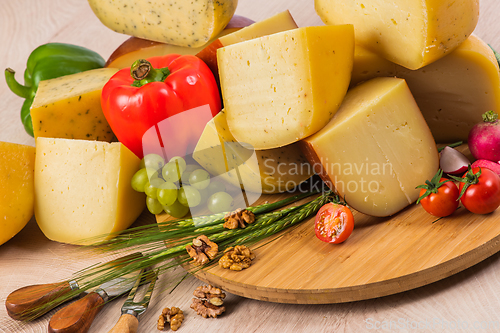 Image of Bosnian traditional cheese served on a wooden container with peppers, parade and onions isolated on a white background