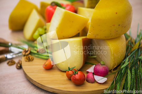 Image of Bosnian traditional cheese served on a wooden container with peppers, parade and onions isolated on a white background