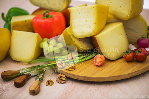 Image of Bosnian traditional cheese served on a wooden container with peppers, parade and onions isolated on a white background