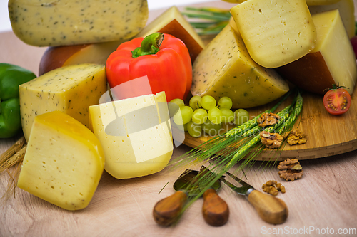 Image of Bosnian traditional cheese served on a wooden container with peppers, parade and onions isolated on a white background