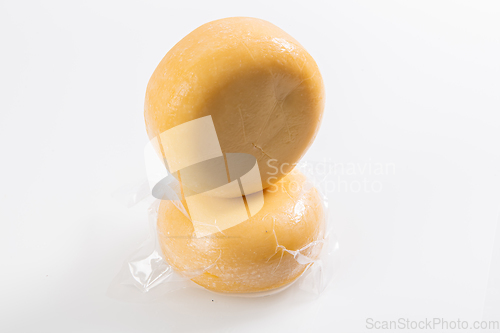 Image of A piece of homemade vacuumed traditional Bosnian cheese isolated on a white background