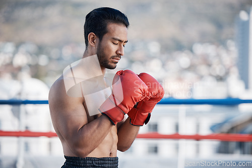 Image of Fitness, boxer praying or man fighting in a ring on rooftop in city for combat training or meditation. Eyes closed, Muay Thai athlete or Asian mma fighter ready for workout, exercise or match battle