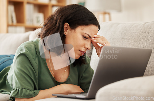 Image of Woman, home and headache with laptop and remote work stress on a sofa feeling frustrated. House, female person and confused from computer problem with anxiety from online website project on a couch