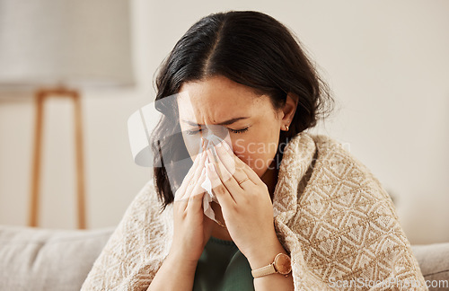 Image of Nose, tissue and sick woman sneezing on a sofa with allergy, cold or flu in her home. Hay fever, allergy and female with viral infection, problem or health crisis in a living room with congestion