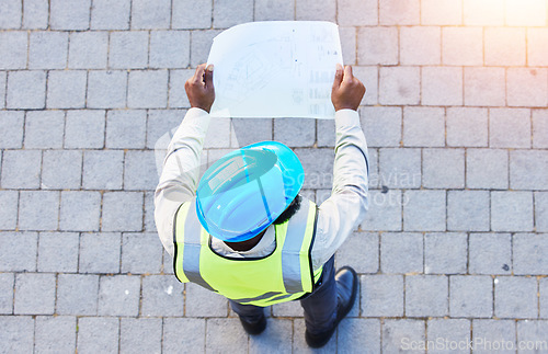 Image of Construction worker, man and building inspection blueprint with industrial employee from above. African male person, professional and builder paperwork with idea and safety plan for engineer project