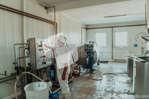 Image of Cheese maker working in the modern industry on machines that are using for the machining of fresh cheese