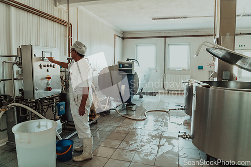 Image of Cheese maker working in the modern industry on machines that are using for the machining of fresh cheese