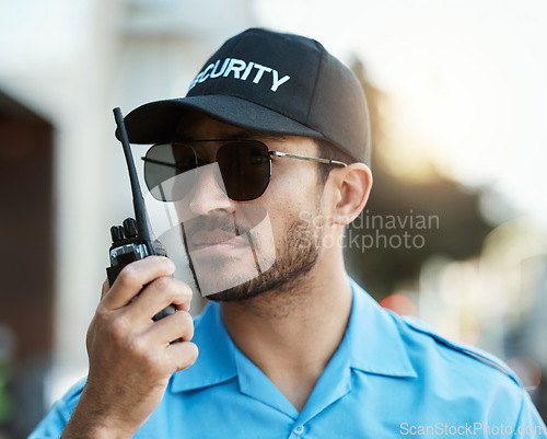 Image of Security guard, safety officer or man with a walkie talkie outdoor on a city road for communication. Serious face of person with a radio on urban street to report crime, investigation or surveillance