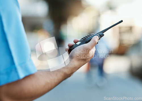 Image of Hand, walkie talkie and a security guard or safety officer outdoor on a city road for communication. Closeup of person with a radio on urban street to report crime for investigation and surveillance