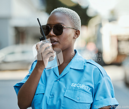 Image of Woman, radio and a security guard or safety officer outdoor on a city road for communication. Black person talking on walkie talkie on urban street to report crime for investigation and surveillance