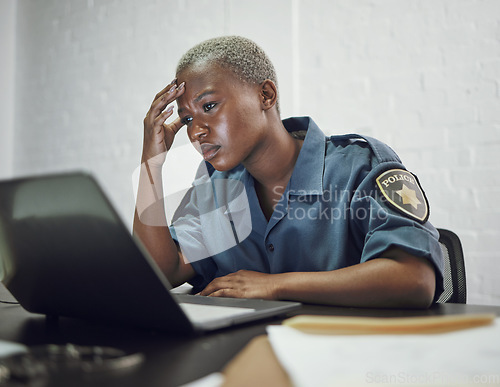 Image of Police, woman and headache from working with stress on computer or frustrated with case, report or anxiety in security. African, officer and tired from work on documents in office or station