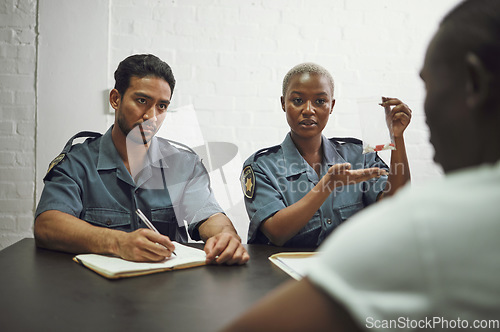 Image of Police, writing and criminal with evidence for interrogation, arrest or investigation report in room. Man and woman, law enforcement or officers asking suspect questions on drugs or crime for justice