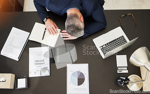 Image of Business man, top view and sleep on desk, office or report with documents, notebook and laptop. Mature CEO, boss or leader with fatigue, paperwork or computer for audit, accounting and tired by table