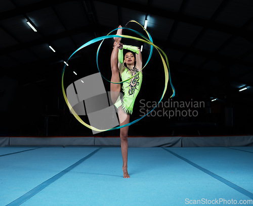 Image of Gymnastics, sports and woman with ribbon in gym for rhythmic body movement, training or exercise. Aerobics performance, health and portrait of female dancer for competition, workout or dance practice