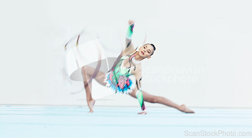 Image of Gymnastics performance, woman and ribbon on floor for competition, sport or fitness with stretching. Gymnast, athlete girl and professional dancer with balance, training or contest with motion blur