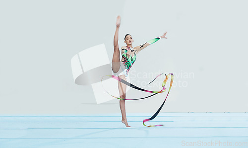 Image of Gymnastics training, woman and ribbon with legs split for competition, sport and balance in portrait. Gymnast, athlete girl or professional dancer for concert, performance and contest with creativity