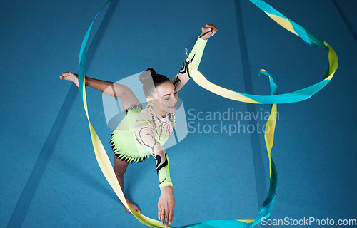 Image of Rhythmic gymnastics, woman in gym and ribbon with balance, action with performance and fitness. Competition, athlete and female gymnast, creativity and art with dancing routine and energy at arena