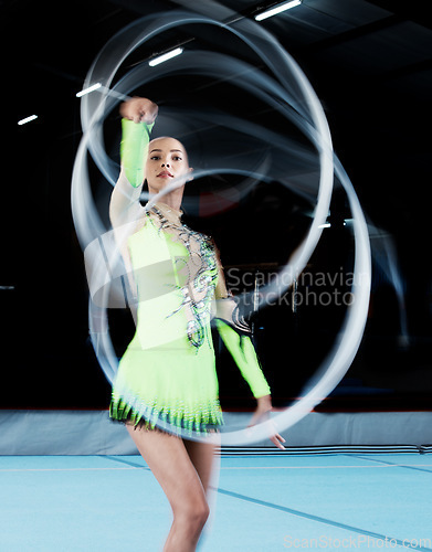 Image of Gymnastics, sports and woman with ribbon blur in gym for rhythmic body movement, training or exercise. Aerobics performance, health and portrait of female dancer for competition, practice and dance