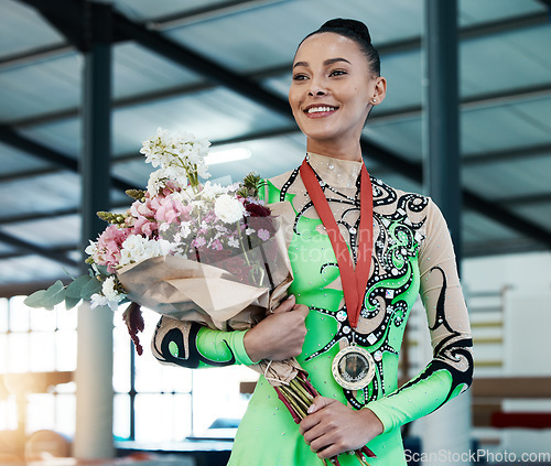 Image of Woman, gymnastics and winner, medal and flower bouquet, happy with celebration and winning competition. Prize, reward and bonus, female champion on podium with gymnast and athlete smile with gift