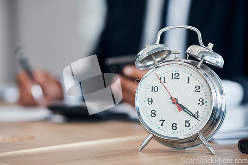 Image of Business man, clock and time management in an office for deadline, punctual and busy schedule. Professional person or broker working at desk with an alarm, reminder and timer for goals and agenda