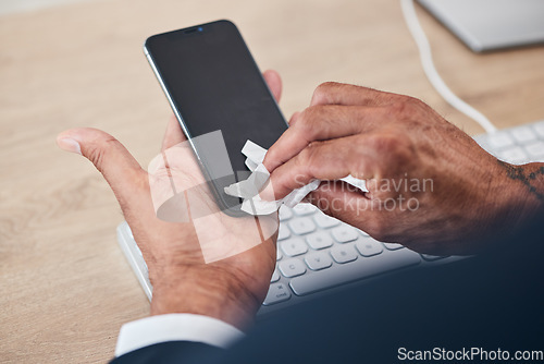 Image of Closeup of man wipe his phone with a tissue to prevent germs, bacteria or dirt in his office. Technology, hands and male person cleaning cellphone screen for hygiene, health and wellness at workplace