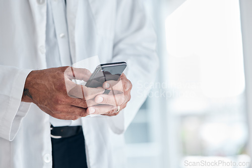 Image of Phone, hands and doctor typing in hospital for research, telehealth and healthcare. Smartphone, medical professional and surgeon, expert or person on mobile app, wellness email or online consultation