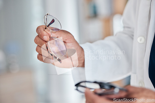 Image of Hands, glasses and optometry with optician in a clinic to recommend prescription frame lens for vision. Healthcare, medical and eyewear with an optometrist holding spectacles for sight and eye care