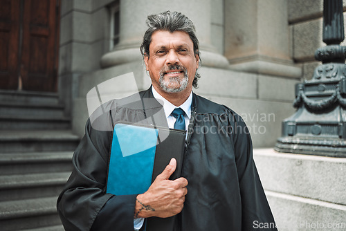 Image of Portrait, book and a senior man judge at court, outdoor in the city during recess from a legal case or trial. Smile, authority and power with a confident magistrate in an urban town to practice law