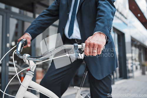 Image of Hands, bicycle and businessman cycling in the city or riding for eco friendly travel, transport or commute to office, building or work. Man, driving and bike for carbon neutral footprint in town