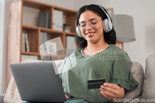 Image of Woman, credit card and headphones for laptop online shopping, e learning and fintech payment on sofa. Student or person for music streaming subscribe, banking services and home education on computer