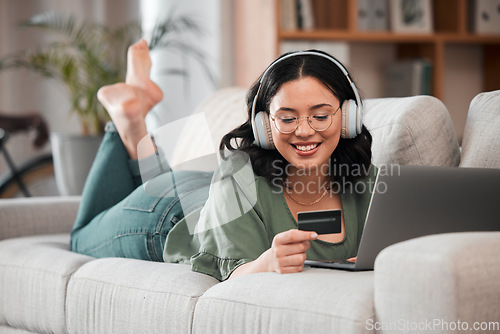 Image of Woman, credit card and headphones on computer online shopping, e learning and fintech payment on sofa. Student or person relax with music subscription, banking services and home education on laptop