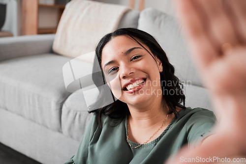 Image of Selfie, happy and portrait of a woman in her living room relaxing, resting or chilling by the sofa. Happiness, smile and young female person from Mexico taking a picture at her modern home apartment.