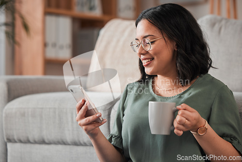 Image of Woman, coffee and typing with phone in living room for social media post, reading notification or tech chat. Happy person, drinking tea and scroll on smartphone, download app and mobile games at home