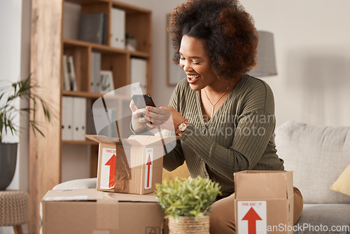 Image of Boxes, phone and woman unboxing for online shopping, courier service and product review on social media. Cardboard package, e commerce and happy african person or influencer on mobile at home on sofa