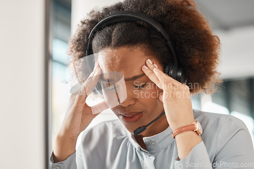 Image of Woman, stress headache and call center in office, headphones and microphone for young crm with pain. African girl, customer care employee and fatigue for contact us, help desk and telemarketing job