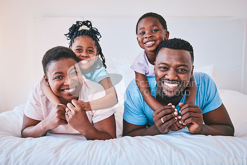 Image of Smile, black family and portrait in a bed happy, care and comfort on the weekend in their home. Face, love and children with parents in bedroom playing, hug and relax while having fun together
