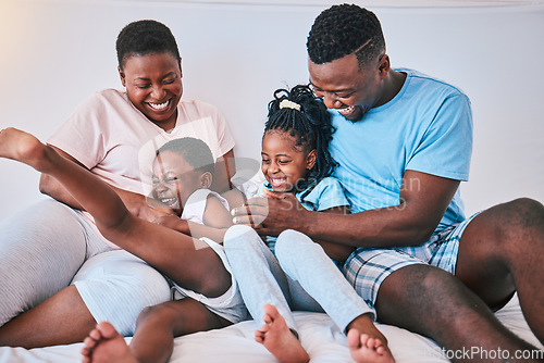 Image of Laugh, black family and tickle in a bed with smile, care and happy on the weekend in their home. People, playing and children with parents in bedroom with games and having fun in the morning together