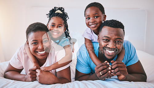 Image of Happy, black family and portrait in a bed with smile, care and comfort on the weekend in their home. Face, love and children with parents in bedroom playing, hug and relax in the morning together