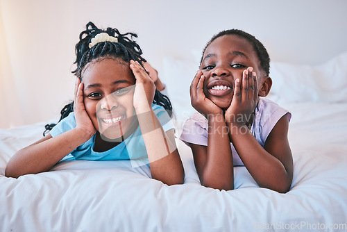 Image of Happy, relax and portrait of children on the bed for playing, bonding and quality time in the morning. Cute, smile and little African kids or siblings in the bedroom of a house for childhood together