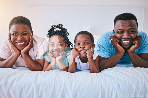 Image of Smile, portrait and black family in bed happy, bond and relax in their home on the weekend. Love, face and children with parents in bedroom playful, free and chilling while enjoying morning together