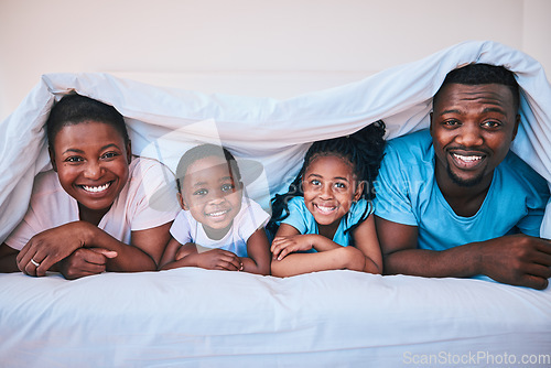 Image of Happy, black family and portrait in a bed with blanket, relax and comfort on the weekend in their home. Face, smile and children with parents in bedroom playing, cover in the morning with fun
